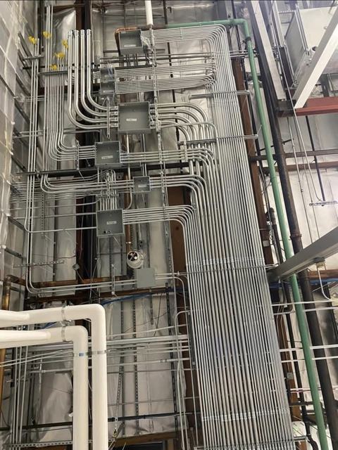 Neat parallel EMT conduit runs with junction boxes in a commercial building